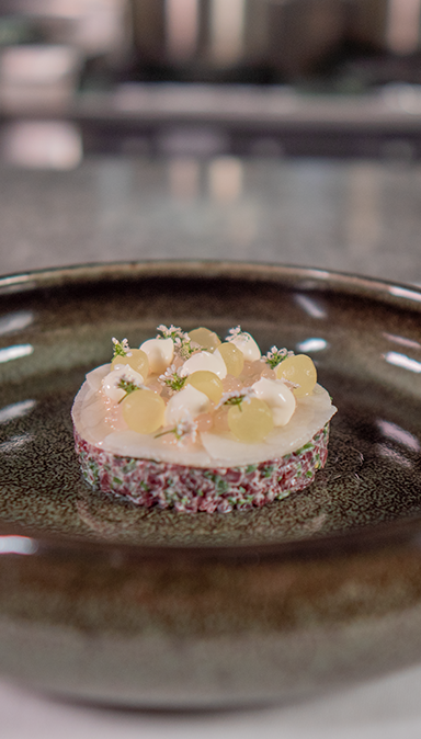 Black and white photo of a women performing modern dance on a dark background.
