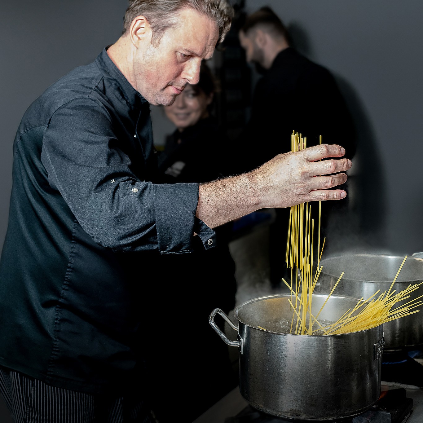 Black and white photo of a women performing modern dance on a dark background.